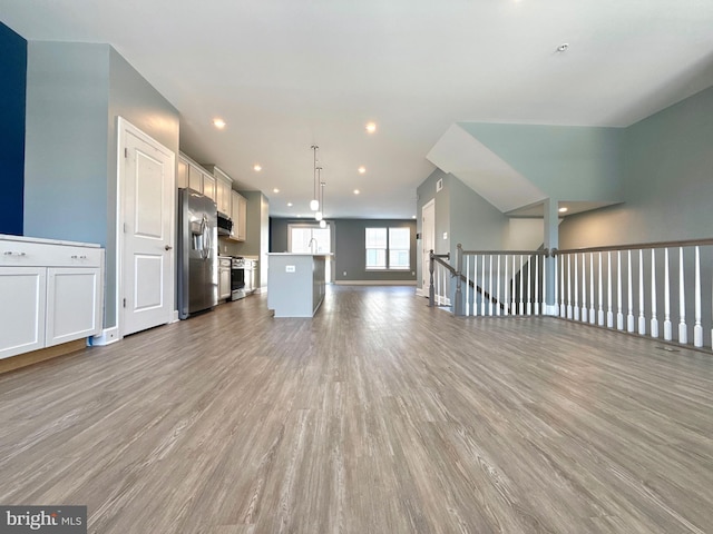 unfurnished living room featuring recessed lighting, baseboards, and wood finished floors
