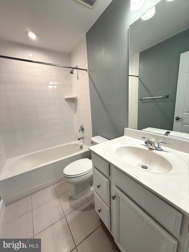 bathroom featuring tile patterned flooring, toilet, vanity, and tub / shower combination