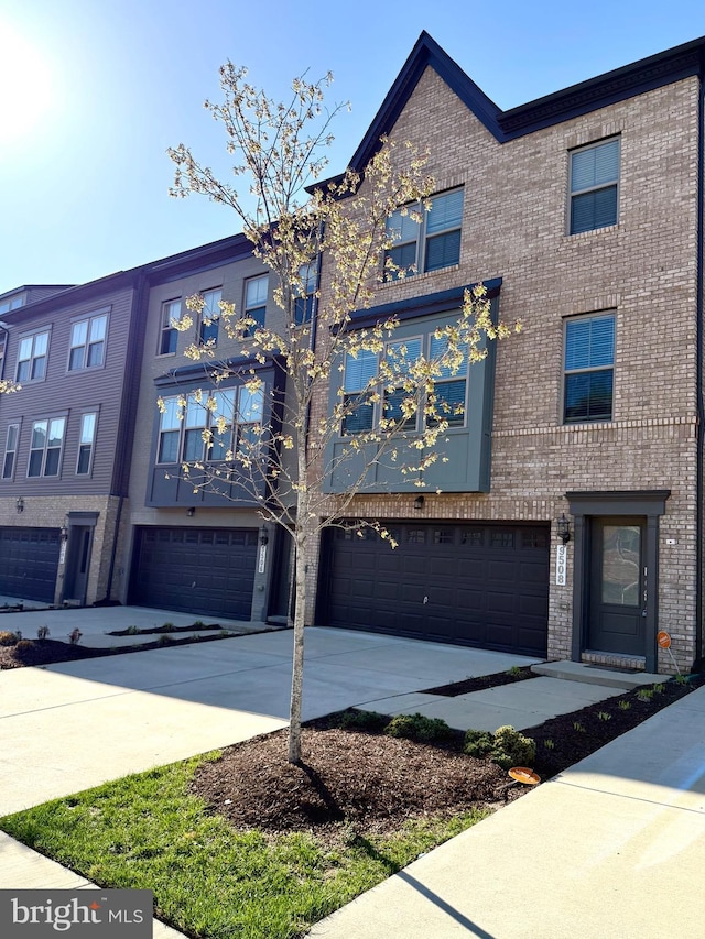 multi unit property featuring a garage, brick siding, and concrete driveway