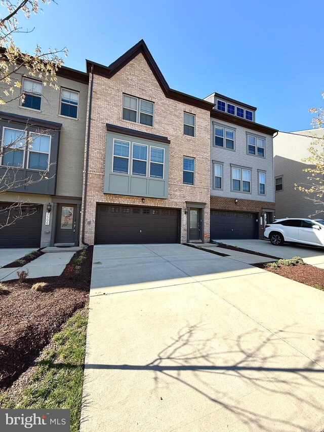 multi unit property featuring concrete driveway, brick siding, and an attached garage