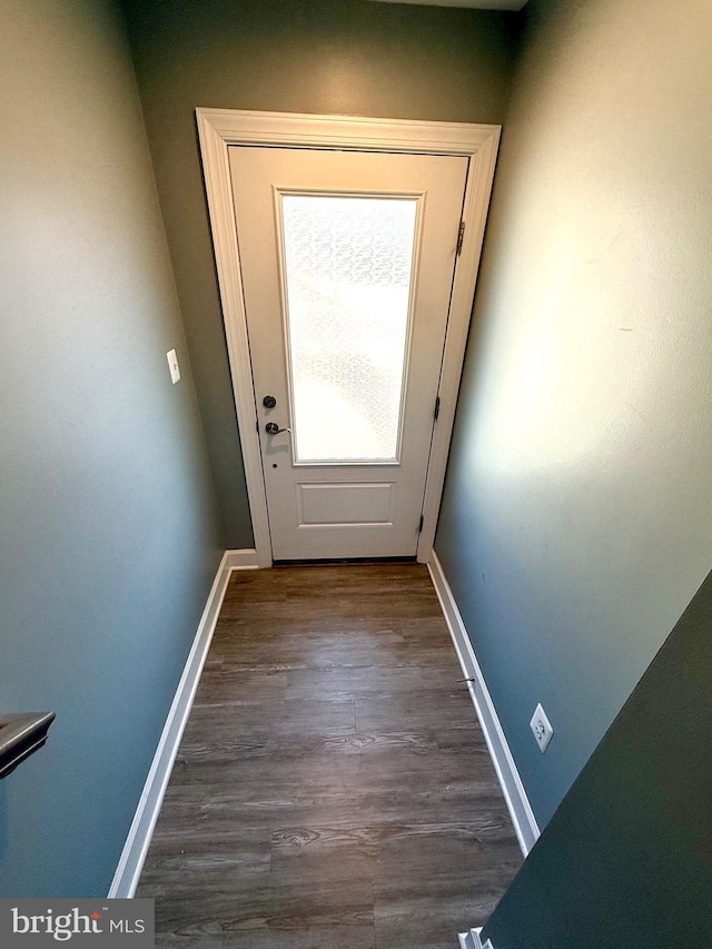 doorway featuring dark wood-style flooring and baseboards