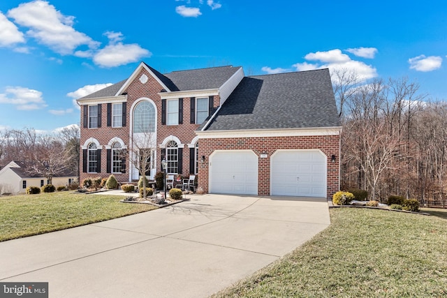 view of front of house featuring brick siding, roof with shingles, concrete driveway, a front yard, and a garage