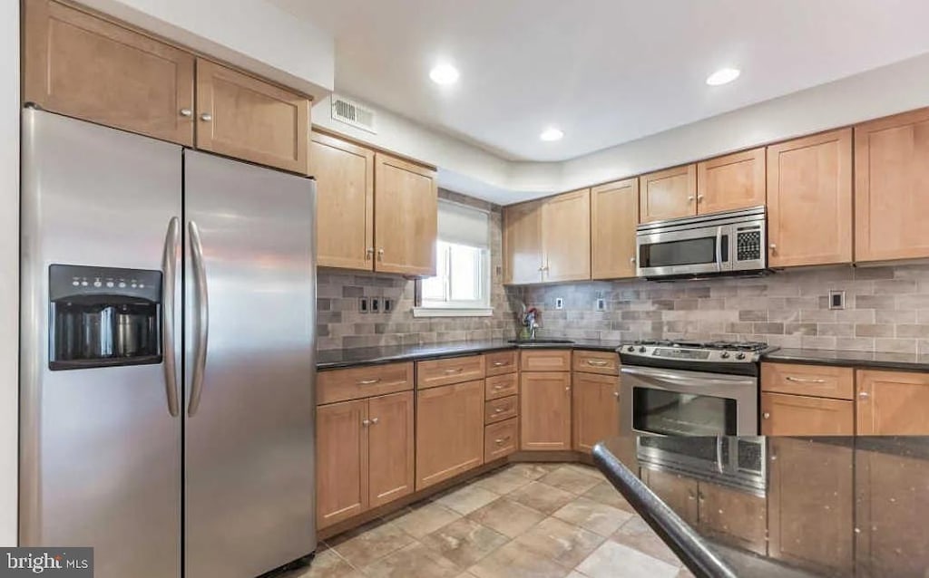 kitchen featuring appliances with stainless steel finishes and tasteful backsplash