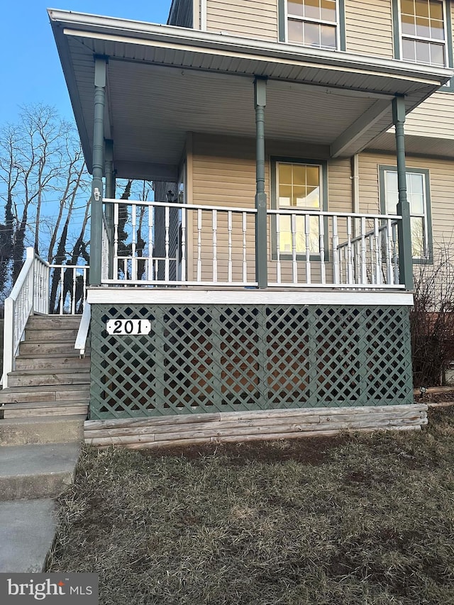 view of home's exterior featuring stairs and a porch