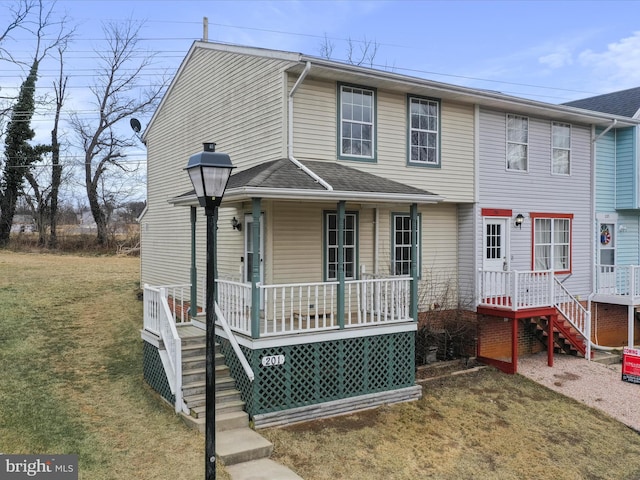 view of front of home featuring a porch, a shingled roof, and a front lawn