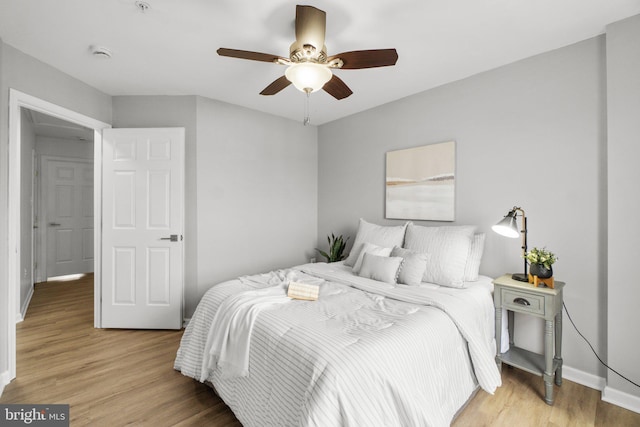 bedroom featuring light wood-style floors, ceiling fan, and baseboards