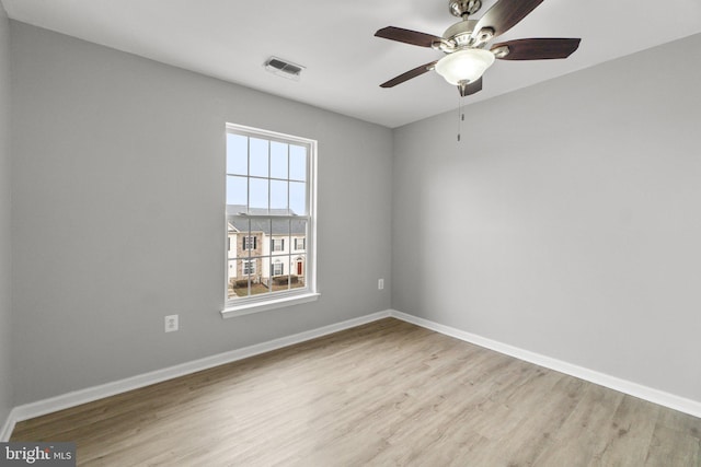 unfurnished room with ceiling fan, light wood-type flooring, visible vents, and baseboards