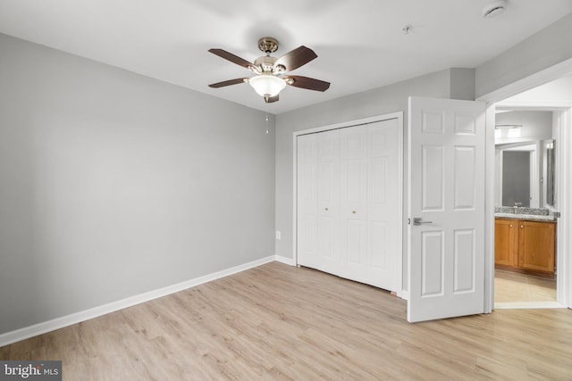 unfurnished bedroom with light wood-type flooring, ceiling fan, baseboards, and a closet