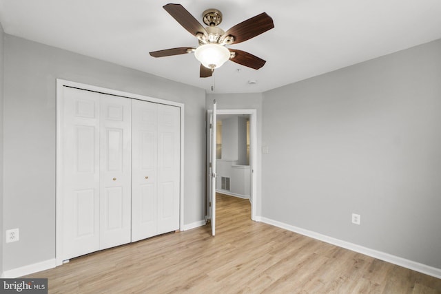 unfurnished bedroom featuring a closet, visible vents, light wood-style flooring, a ceiling fan, and baseboards