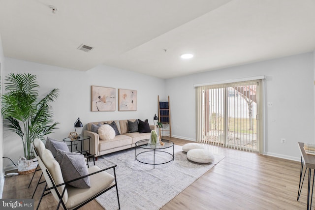 living area featuring light wood-type flooring, baseboards, and visible vents