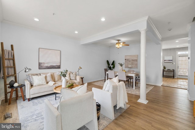 living room with decorative columns, light wood finished floors, recessed lighting, a ceiling fan, and ornamental molding