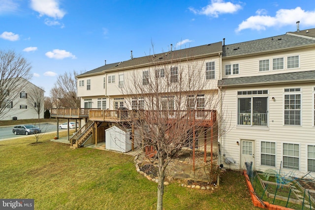 rear view of property featuring stairs, a deck, and a lawn