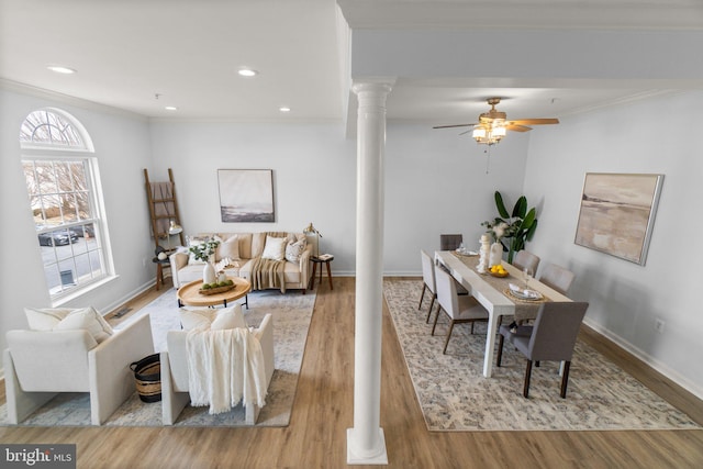 living room with ornate columns, light wood-style flooring, baseboards, and ornamental molding