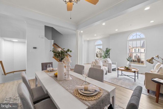 dining space with plenty of natural light, light wood-style flooring, decorative columns, and ornamental molding