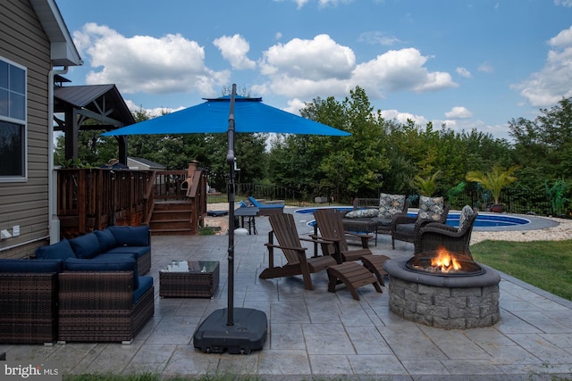 view of patio / terrace featuring a fenced in pool and an outdoor living space with a fire pit