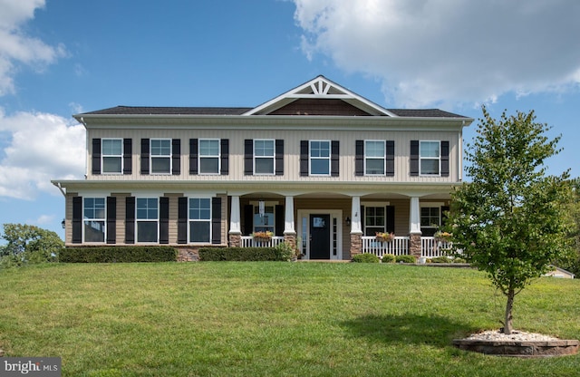 view of front of property featuring covered porch and a front yard