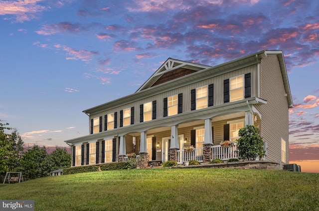 view of front facade featuring a yard, cooling unit, and a porch