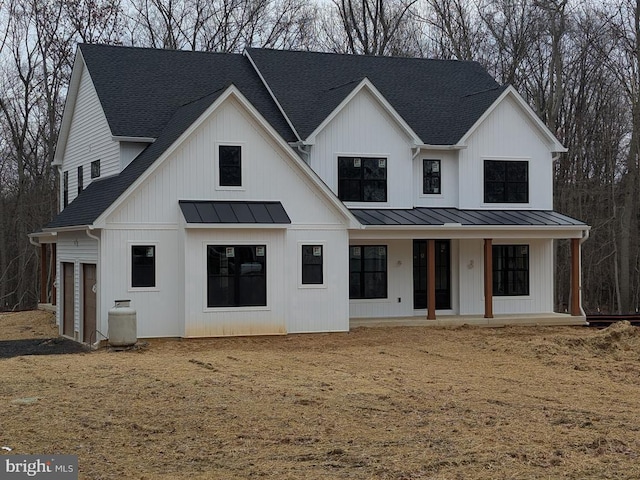 modern farmhouse style home featuring metal roof, a porch, a standing seam roof, and a shingled roof