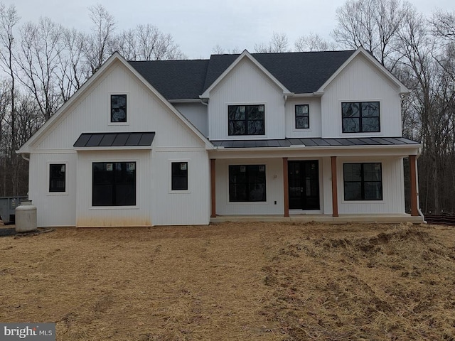 modern farmhouse featuring metal roof, roof with shingles, a standing seam roof, and covered porch