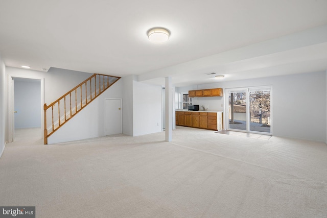 unfurnished living room featuring light colored carpet