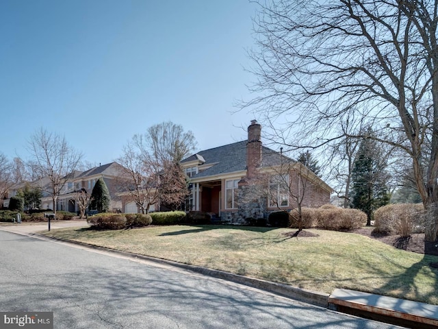 view of side of home featuring a garage, driveway, a yard, and a chimney