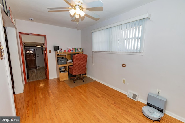 office space with ceiling fan, baseboards, visible vents, and light wood-type flooring