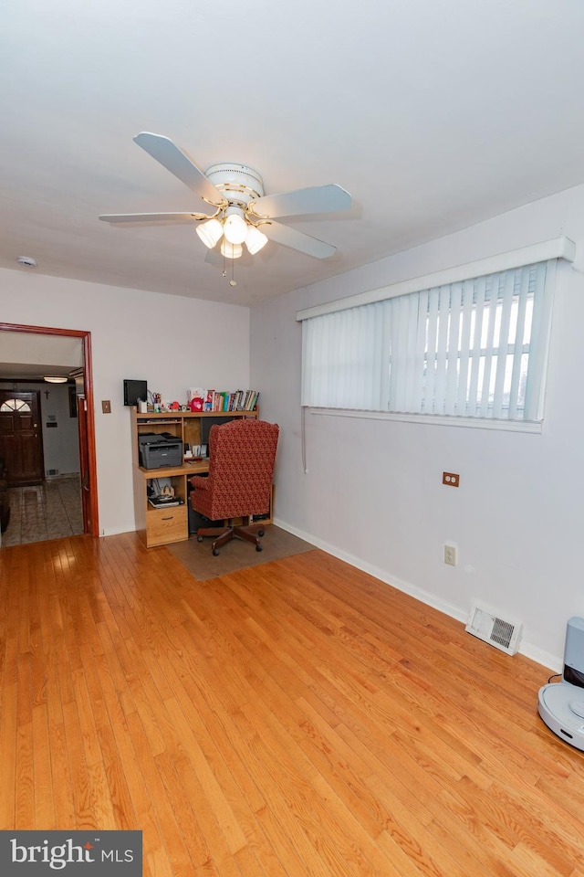 office with visible vents, baseboards, ceiling fan, and wood-type flooring