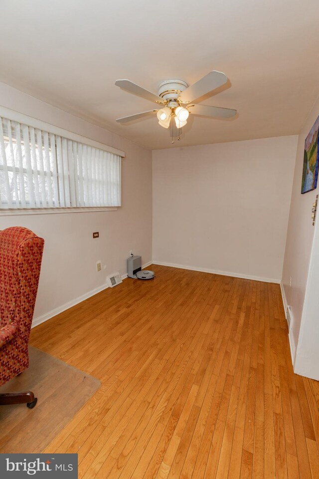 interior space with light wood-type flooring, baseboards, and a ceiling fan