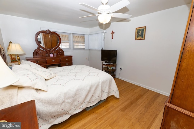 bedroom with baseboards, light wood-style floors, and a ceiling fan