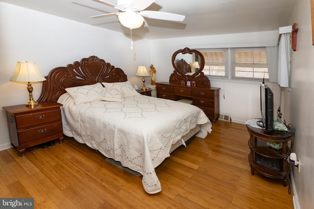 bedroom featuring visible vents, a ceiling fan, and light wood-style floors