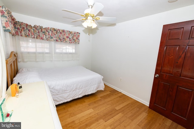 bedroom featuring baseboards, light wood finished floors, and ceiling fan