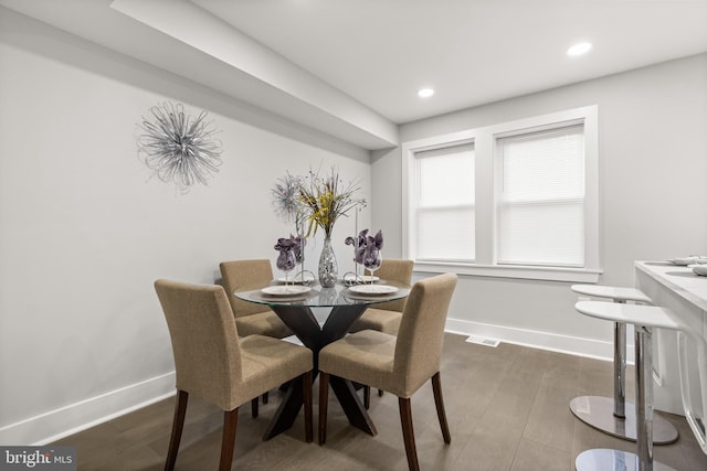 dining room with dark wood-style floors, recessed lighting, visible vents, and baseboards