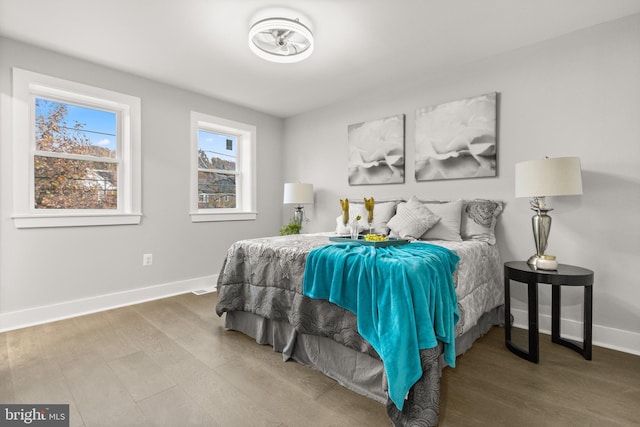 bedroom with baseboards and wood finished floors