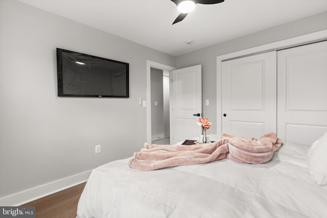 bedroom featuring dark wood-style floors, ceiling fan, a closet, and baseboards