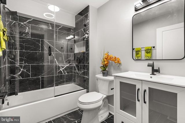 bathroom with marble finish floor, shower / bath combination with glass door, vanity, and toilet