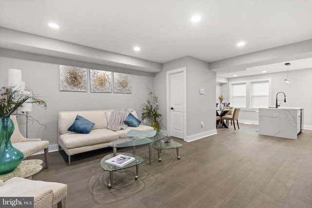 living room with baseboards, wood finished floors, and recessed lighting