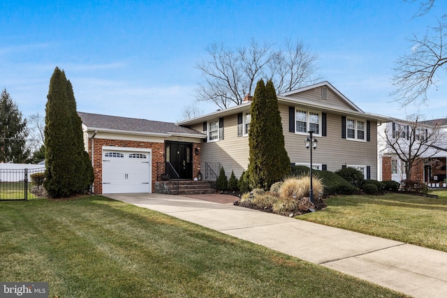 split level home with a garage, driveway, brick siding, fence, and a front yard