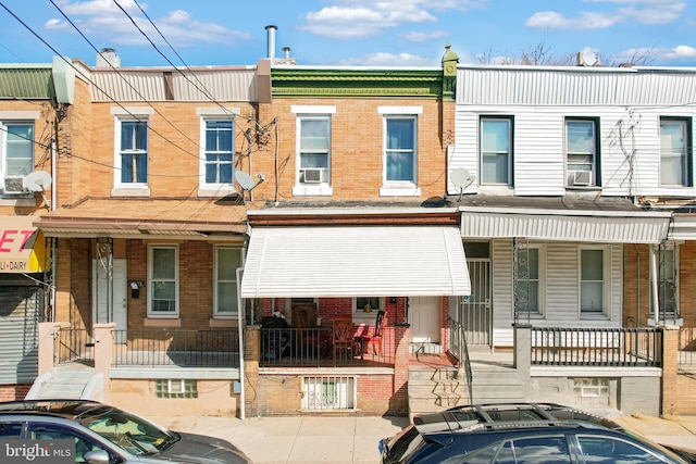 view of property featuring covered porch and brick siding