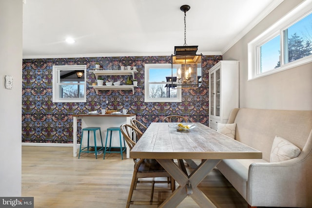 dining room with crown molding, baseboards, and wallpapered walls