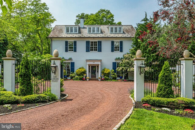 240 Library Pl, Princeton, NJ 08540 - view of front facade featuring stucco siding, driveway, a high end roof, and a chimney