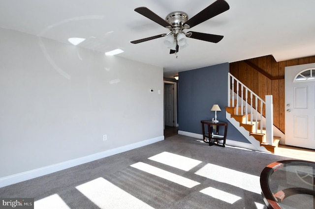 unfurnished living room with dark carpet and wooden walls