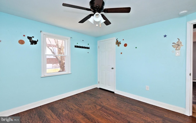 unfurnished room featuring dark wood-type flooring and ceiling fan