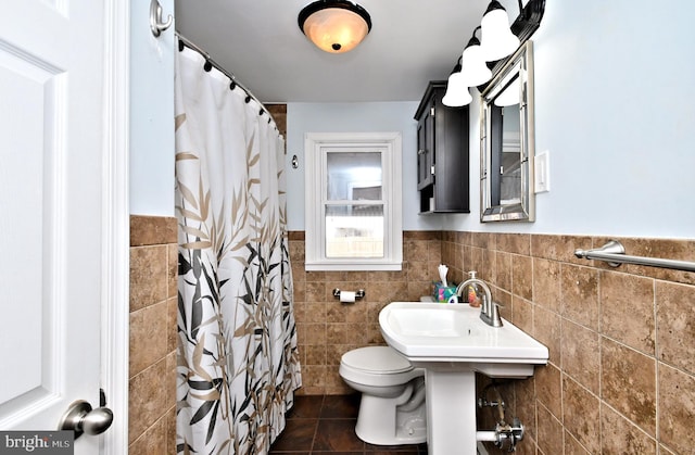 bathroom with tile patterned flooring, toilet, a shower with curtain, tile walls, and sink