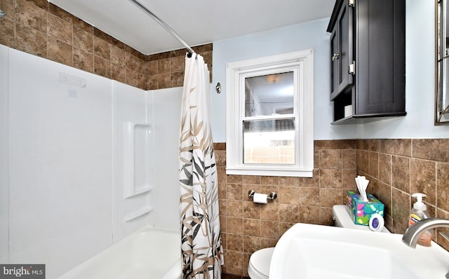 full bathroom featuring tile walls, sink, toilet, and shower / tub combo