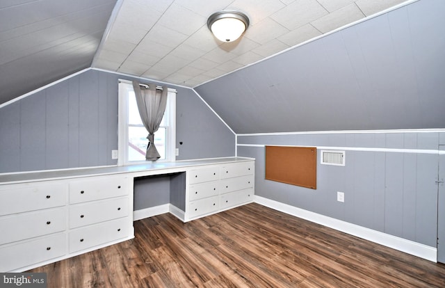 additional living space with built in desk, vaulted ceiling, and dark hardwood / wood-style floors