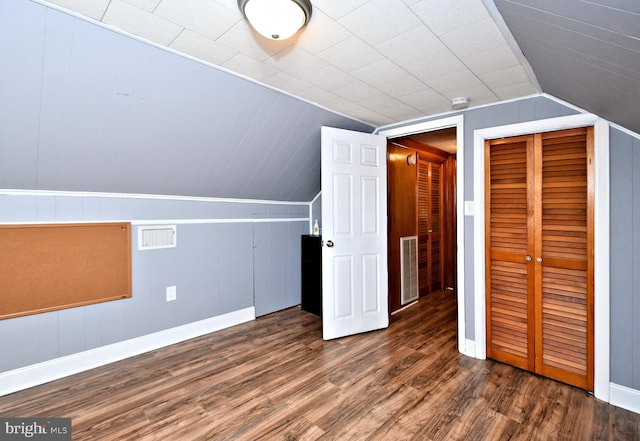 additional living space with vaulted ceiling and dark wood-type flooring