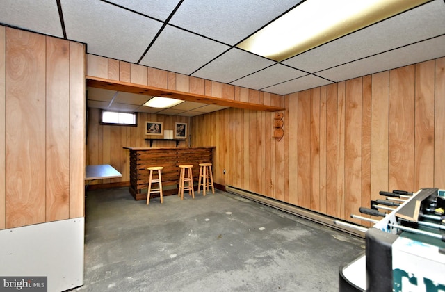 interior space with wooden walls and a drop ceiling