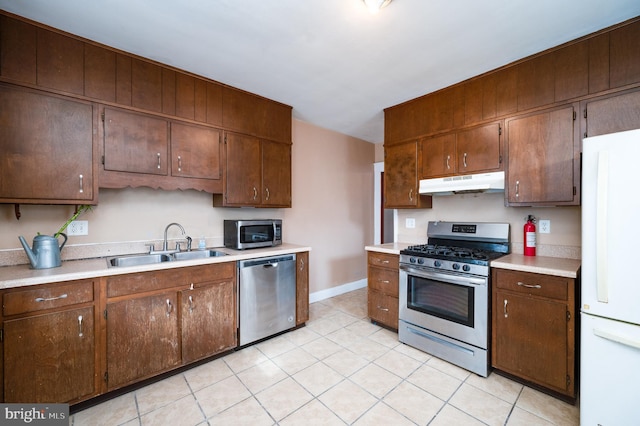 kitchen with sink, appliances with stainless steel finishes, and light tile patterned flooring