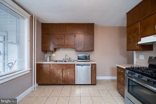 kitchen with sink, appliances with stainless steel finishes, and light tile patterned floors