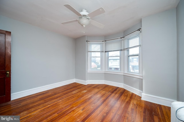 empty room featuring ceiling fan and dark wood-type flooring